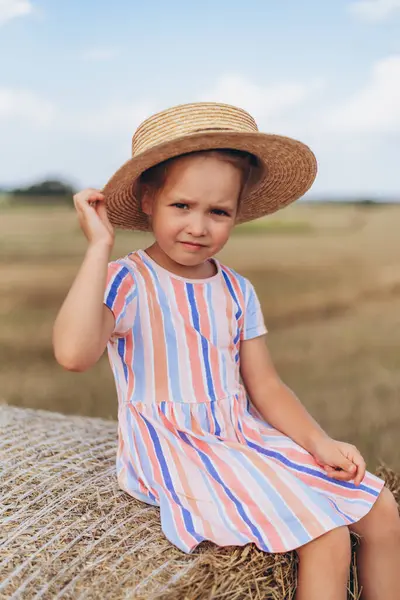 여름에 줄무늬와 모자를 드레스 베일에 거리를 바라보고 그녀의 손으로 그녀의 로열티 프리 스톡 사진
