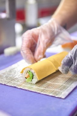 Nigiri, rulo ve sashimi 'den oluşan canlı bir suşi çeşidi. Koyu bir levhada güzelce yerleştirilmiş. Canlı renkler ve dokular deniz ürünlerinin çeşitliliğini ve tazeliğini vurgular..