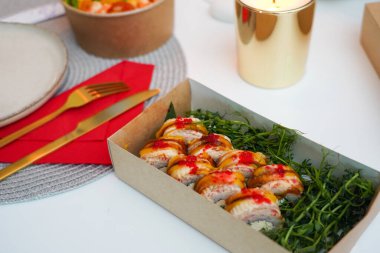 Elinizde bambu çubukları, restoranda soya sosuyla ıslatırken nefis bir suşi. Ön manzara. Japon mutfağı kavramı.