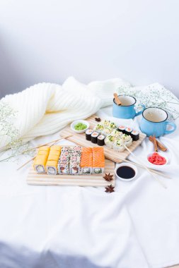 Elinizde bambu çubukları, restoranda soya sosuyla ıslatırken nefis bir suşi. Ön manzara. Japon mutfağı kavramı.