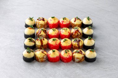 Elinizde bambu çubukları, restoranda soya sosuyla ıslatırken nefis bir suşi. Ön manzara. Japon mutfağı kavramı.