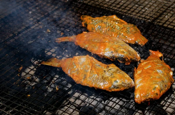 Delicious Asian fish fry served on a BBQ table. Grilled fish laid on steel grates in Trincomalee Sri lanka