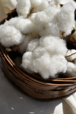 Pamuk çiçeklerini beyaz kumaşla sepete koy.