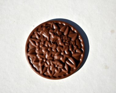 Beyaz arka planda izole edilmiş çiçek şeklinde yuvarlak çikolata, üst görünüm