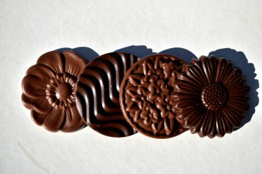 Beyaz arka planda izole edilmiş dört çeşit yuvarlak çikolata, üst görünüm