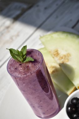 Karpuz dilimlerinin üst görüntüsü ve beyaz tabakta yabanmersini ve meyve püresi.