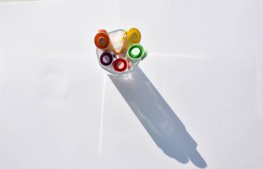 beyaz arkaplanda izole edilmiş bir bardaktaki çok renkli işaretler, üst görünüm