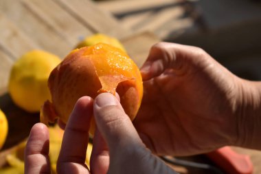Şeftali soyan bir elin yakın çekimi.