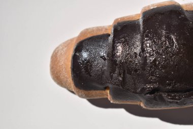 Çikolatalı kruvasan beyaz tabakta çikolata jölesiyle kaplanmış. Makro fotoğrafçılık. Boşluğu kopyala