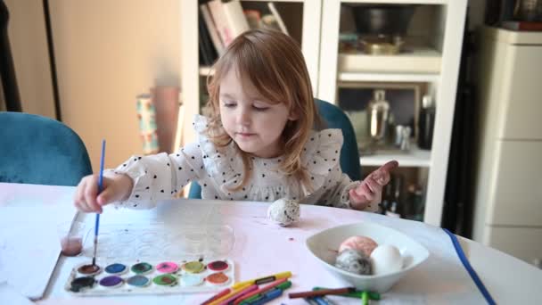 Mała Dziewczynka Siedzi Przy Stole Maluje Wielkanocne Jajka Rysuje Jest — Wideo stockowe
