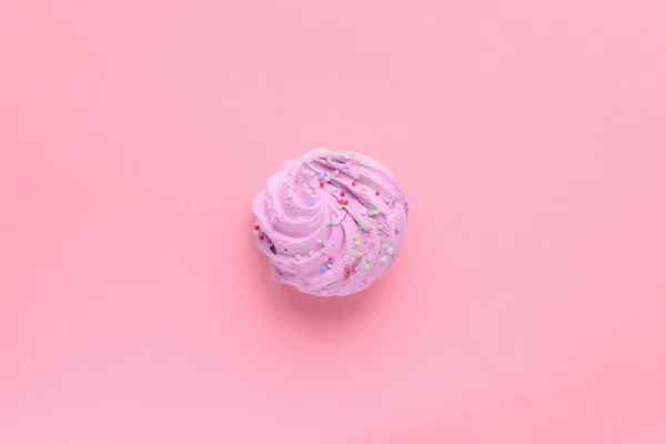 stock image Still life of a very colorful meringues, with colored sprinkles on, placed on a pink background. A single purple meringue is lying in the middle of the frame. Plenty of copy space around.