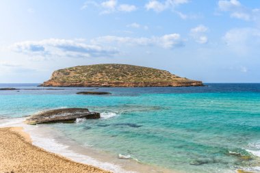 İbiza, İspanya 'daki çok popüler Cala Comte plajı ya da Cala Conta. Bu plajın boş olması çok nadirdir. Cala Comte, İbiza 'da günbatımını izlemek için en iyi yerlerden biridir. Önündeki küçük isimsiz ada İbiza 'nın simgesidir..