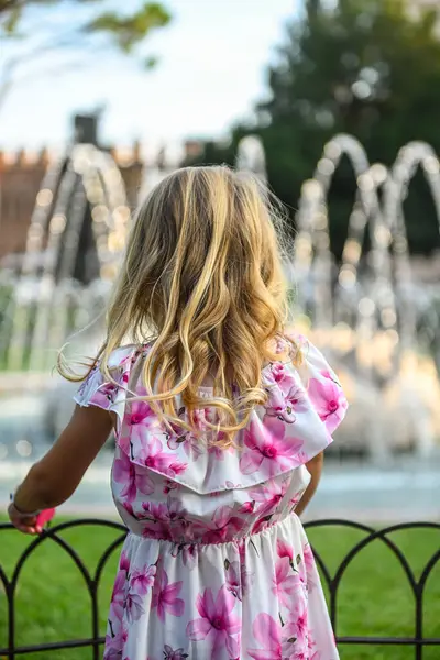이탈리아 베로나의 공원에서 아름다운 드레스 머리와 귀여운 소녀는 카메라로 그녀를 로열티 프리 스톡 사진