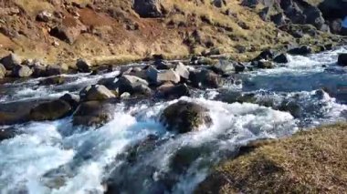Kayaların üzerinden İzlanda 'daki Kerlingarfoss şelalesinin yakınına akan güçlü bir akarsu. Su Kerlingara buzulundan geliyor. Güneşli bir bahar günü.