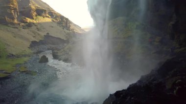 İzlanda 'daki ünlü Kvernufoss şelalesi, şelalenin arkasındaki mağaradan görülüyor. Havada şelaleden gelen bir sürü sprey var. Kvernufoss, daha ünlü olan Skogafoss şelalesinin yanında yer almaktadır.