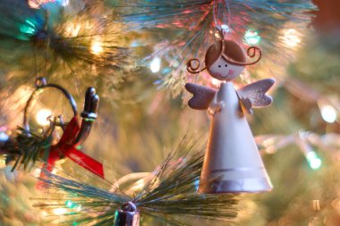 Noel ağacında asılı olan melek süslemelerine yakın, bulanık arka planda, Noel ışıklarıyla. Metin için alanı kopyala.