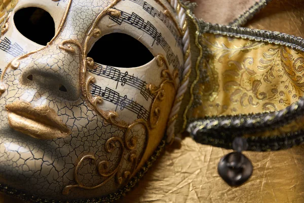 Altın Venedik maskesini kapatın, altın yüzeyle ilgili detaylar ve notalarla süslü karnaval maskesi.