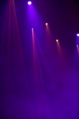 Sahne ışıklarının koyu arkaplandaki mor ışıkları.