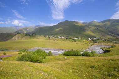 A beautiful mountain landscape with a small meandering river and a blue sky. Mountainous Georgia.
