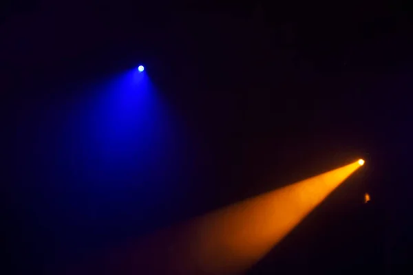 Orange beams of light from stage spotlights on a dark blue background.Illumination of the stage.