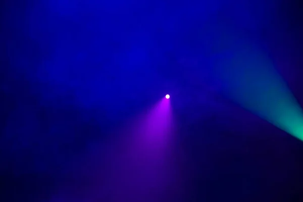 Green and purple light beam on a dark blue smoky background.