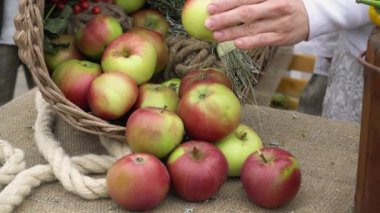 wicker basket with ripe colorful apples in the village.