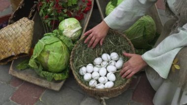 White eggs in a basket and a head of cabbage standing on the side isolated on a background of grass, the concept of eggs is fresh from the farm