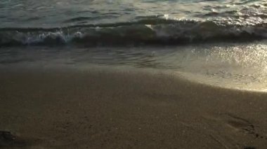 Soft blue sea wave on a sandy beach. Black sand of a magnetic beach.