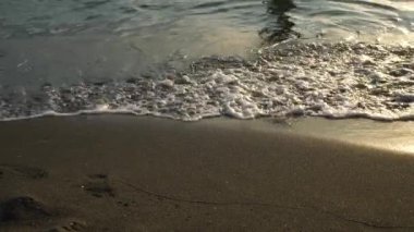 Soft blue sea wave on a sandy beach. Black sand of a magnetic beach.