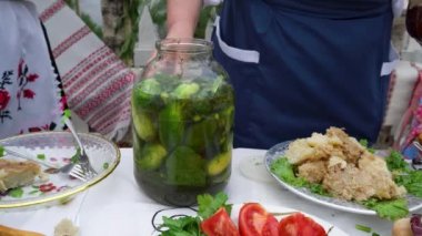 Canned cucumbers in a glass transparent jar.