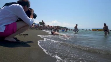 Georgia. Ureki August 10, 2022 . Mom takes a picture of a child on the beach.