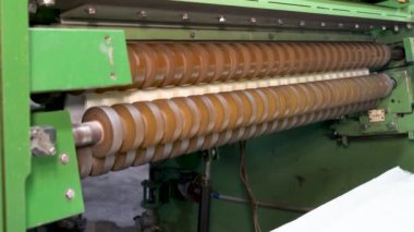 An industrial machine makes wallpaper.