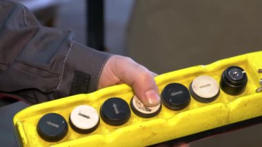 The worker presses the button on the control panel of the mechanism.