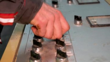 The worker presses the button on the control panel of the mechanism.