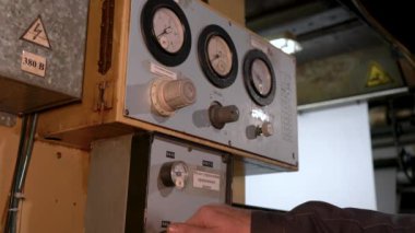 The worker presses the button on the control panel of the mechanism.