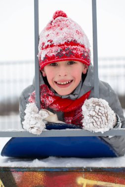Karla kaplı kırmızı kış şapkalı bir çocuğun portresi..