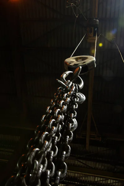 Metal industrial chains with hooks in the workshop of a metallurgical plant.