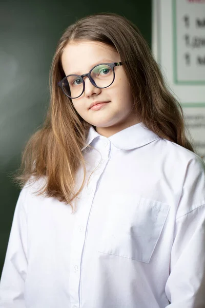 站在黑板后面 戴着中学时代眼镜的漂亮女孩 — 图库照片