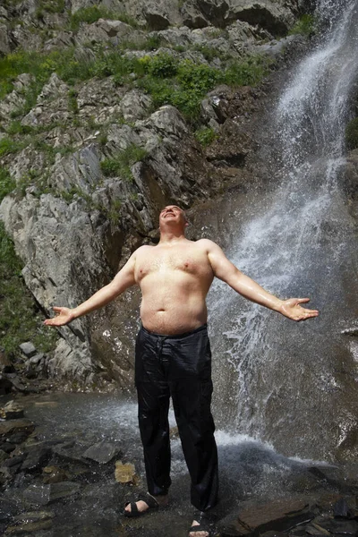 Starszy Mężczyzna Stoi Przy Górskim Wodospadzie Rozkłada Ramiona Cieszy Się — Zdjęcie stockowe