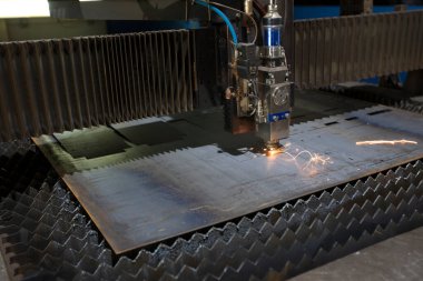 Metal kesimi. Lazerden kıvılcımlar saçılır. Lazer kesme makinesi fabrikada kıvılcımlar saçan levha metallerle çalışır..