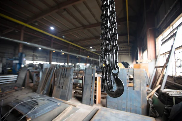 Metal industrial chains with hooks in the workshop of a metallurgical plant.
