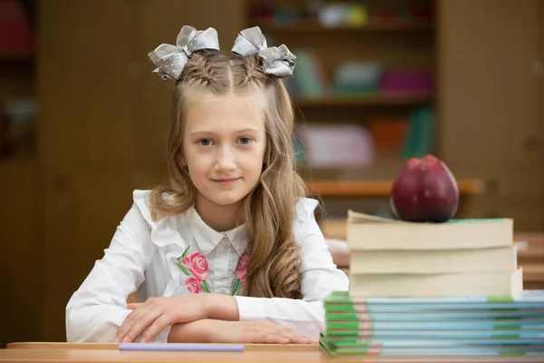 机の上に弓を持った美しい女子高生 本とリンゴを持つ教室の女の子 中等学校 学校に戻る — ストック写真