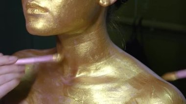 Moda sanatı, altın tenli kadın portresi. Altın dudakların ve tenin güzelliği. Manken kız. Göz kamaştırıcı parlak profesyonel makyaj.