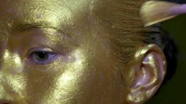 Moda sanatı, altın tenli kadın portresi. Altın gözlerin ve tenin güzelliği. Manken kız. Göz kamaştırıcı parlak profesyonel makyaj..