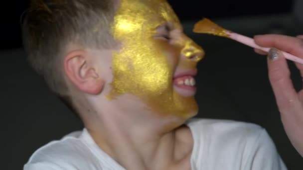 这个男孩的脸上涂满了金色的油漆 — 图库视频影像