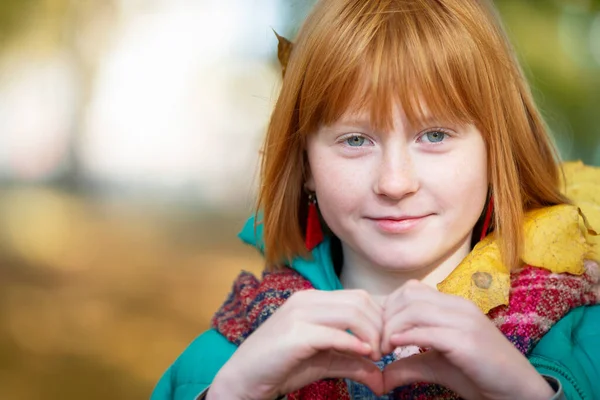 Рыжеволосая Девушка Осеннем Парке Показывает Знак Сердца — стоковое фото