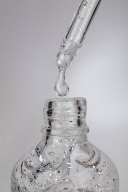 Pipetinden gümüş kıvılcımlar akan kozmetik serumu.