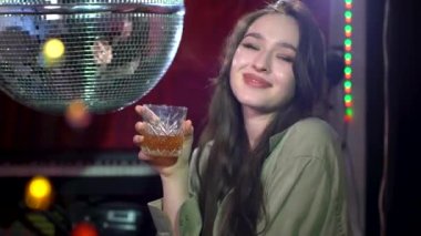 Disko barında bir kız tezgahta rahatlıyor ve içki içiyor..