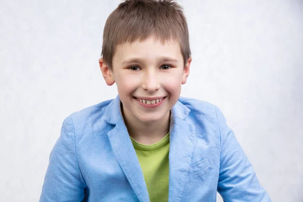 Ένα Όμορφο Αγόρι Μπλε Σακάκι Χαμογελάει Και Κοιτάζει Την Κάμερα — Φωτογραφία Αρχείου