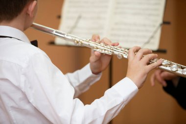 Çocuk parlayan flüt çalıyor. Rüzgar müzik aleti.
